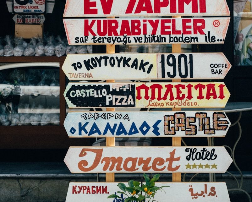 Panneaux de restaurants affichant des noms variés en différentes langues.